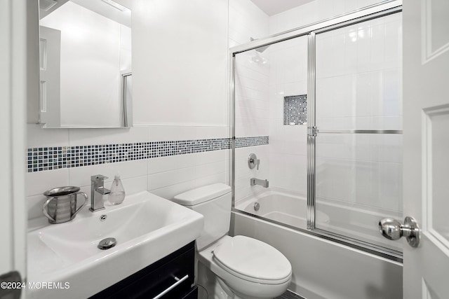 full bathroom featuring vanity, enclosed tub / shower combo, tile walls, and toilet