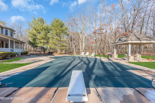 view of swimming pool with a gazebo, a patio, and a diving board