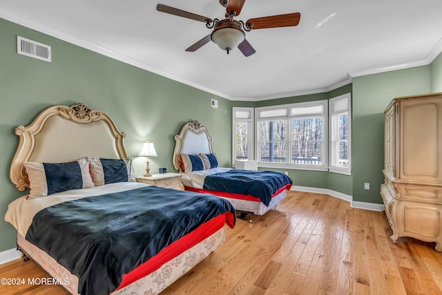 bedroom featuring light hardwood / wood-style floors, ceiling fan, and crown molding