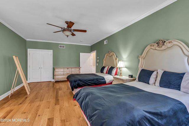 bedroom with light wood-type flooring, a closet, ceiling fan, and crown molding