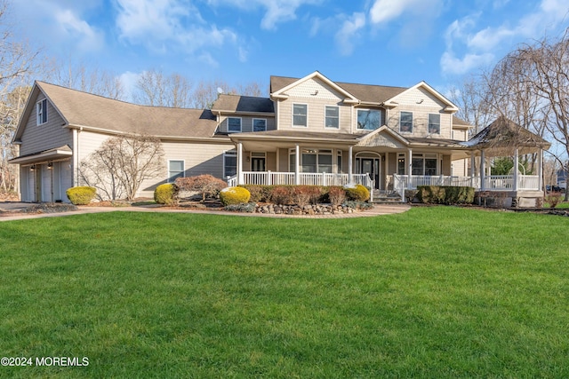 view of front of property featuring a garage, covered porch, and a front lawn