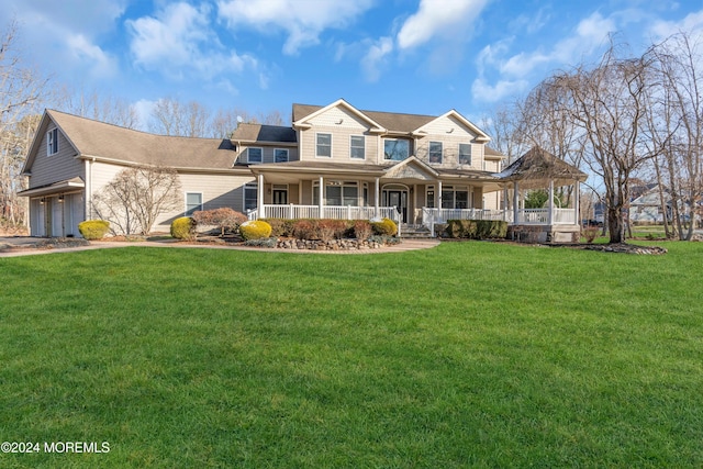 view of front of property with a garage, covered porch, and a front yard