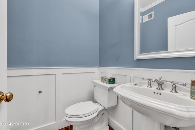 bathroom with sink, ornamental molding, and toilet