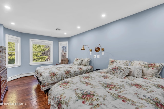 bedroom with dark hardwood / wood-style flooring and a baseboard radiator