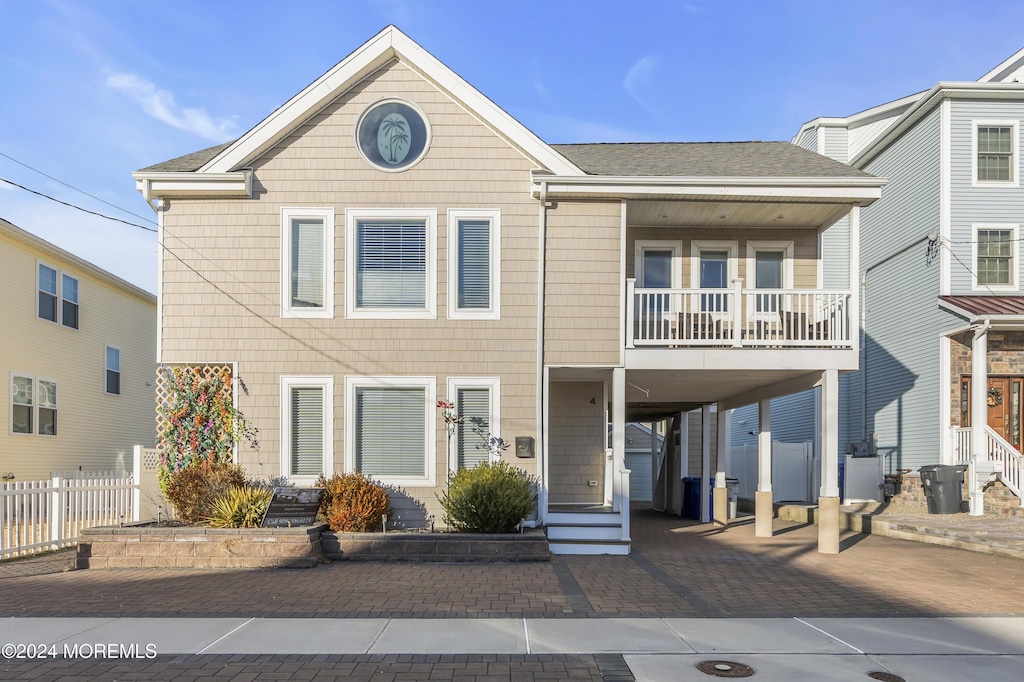 view of front facade featuring a carport and a balcony