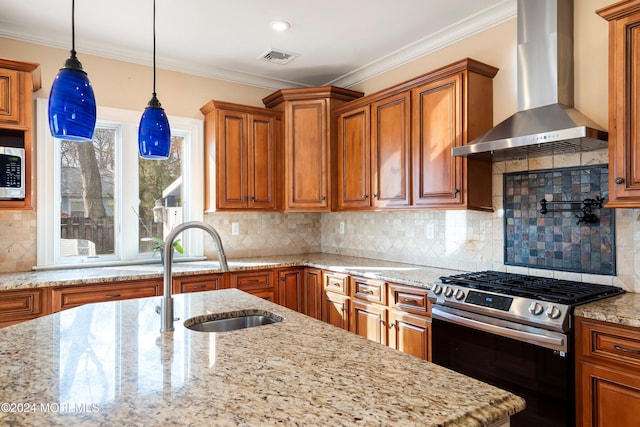 kitchen featuring sink, wall chimney exhaust hood, light stone counters, decorative backsplash, and appliances with stainless steel finishes