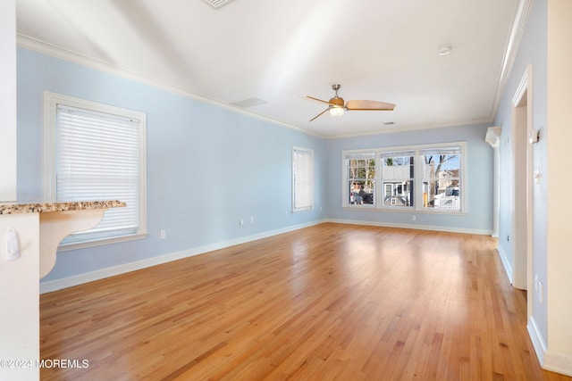 unfurnished living room with ceiling fan, light wood-type flooring, and ornamental molding