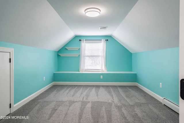 additional living space featuring carpet, vaulted ceiling, and a baseboard heating unit