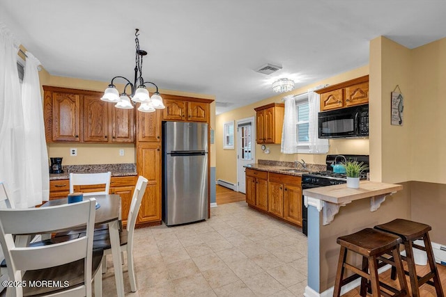 kitchen with black appliances, decorative light fixtures, baseboard heating, and sink