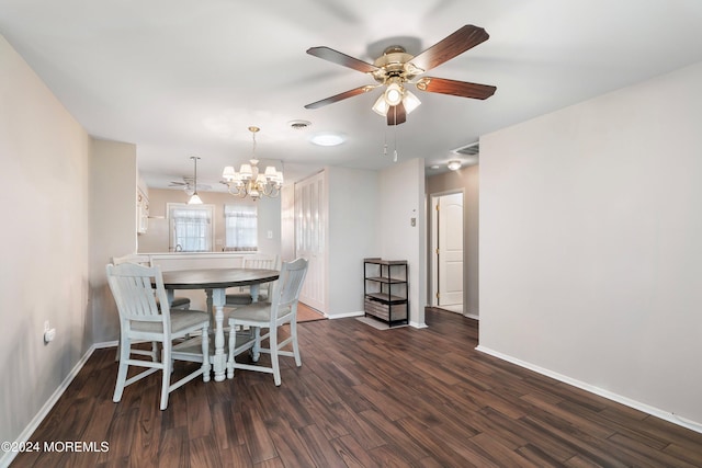 dining room with ceiling fan with notable chandelier and dark wood-type flooring