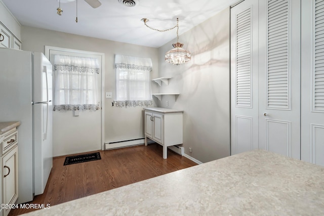 unfurnished bedroom with a notable chandelier, white refrigerator, dark hardwood / wood-style flooring, and baseboard heating