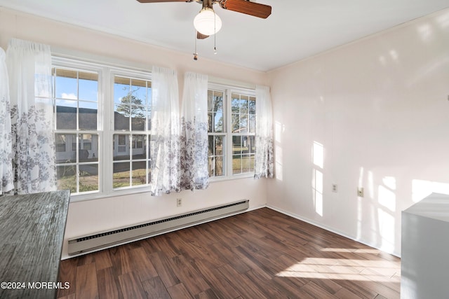 empty room featuring baseboard heating, a wealth of natural light, and hardwood / wood-style floors