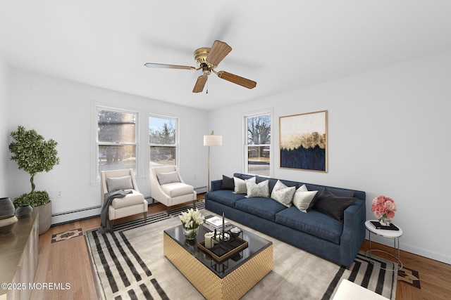 living room with ceiling fan, a baseboard heating unit, and light hardwood / wood-style flooring