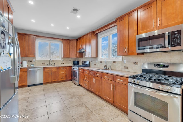 kitchen with sink, stainless steel appliances, and tasteful backsplash