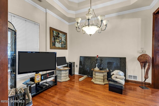 sitting room with hardwood / wood-style floors, a tray ceiling, crown molding, and a notable chandelier