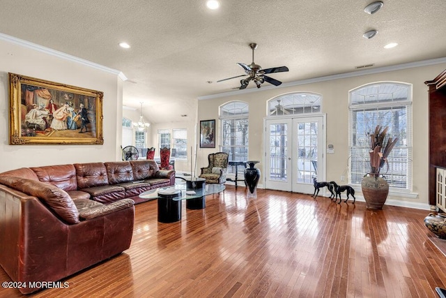 living room with french doors, crown molding, hardwood / wood-style floors, and a textured ceiling