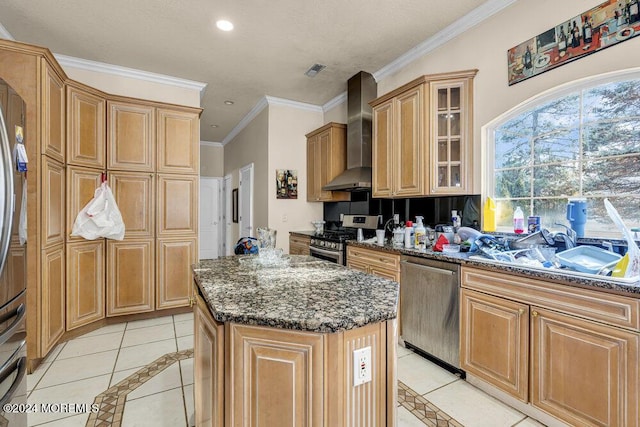 kitchen with a center island, sink, stainless steel appliances, wall chimney range hood, and light tile patterned flooring