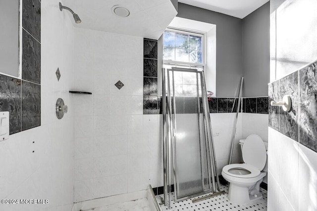 bathroom with tiled shower, tile walls, and toilet