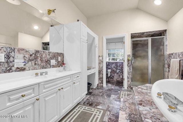 bathroom featuring vanity, independent shower and bath, and lofted ceiling