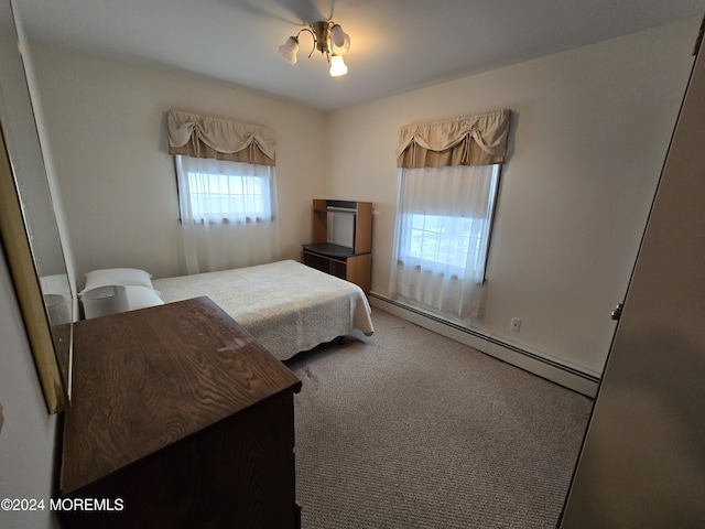 bedroom with a baseboard heating unit and carpet floors