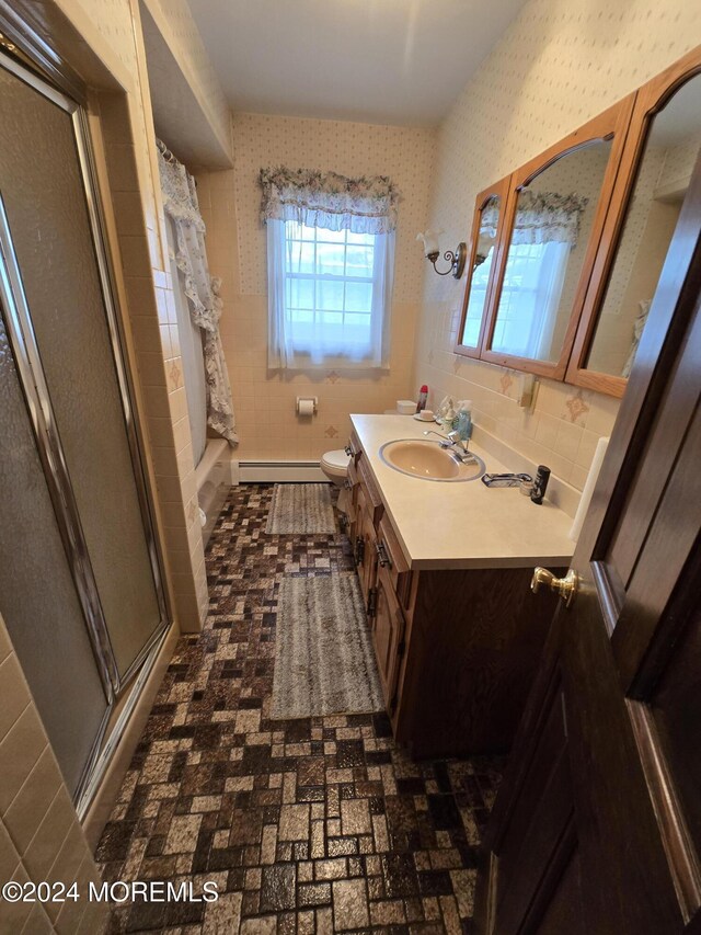 bathroom featuring baseboard heating, toilet, vanity, and wallpapered walls