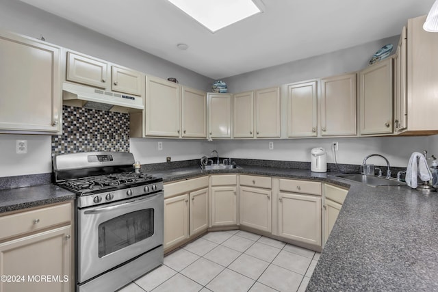 kitchen with gas range, light tile patterned floors, and sink