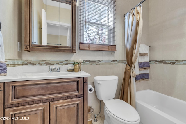 full bathroom with vanity, shower / bathtub combination with curtain, tile walls, and toilet