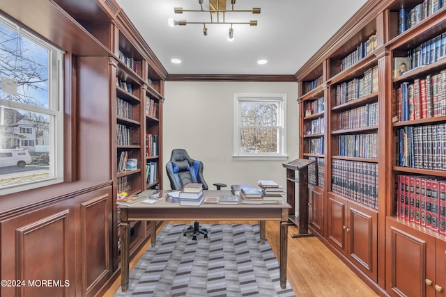 home office featuring light wood-type flooring and crown molding