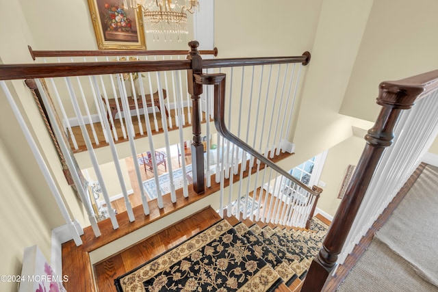 staircase featuring a chandelier and wood-type flooring