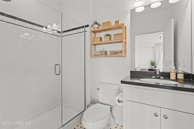 bathroom featuring tile patterned floors, vanity, toilet, and a shower with shower door