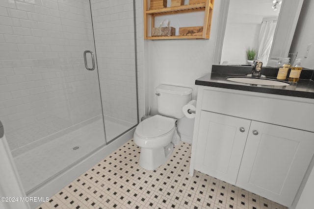 bathroom with tile patterned floors, toilet, vanity, and walk in shower