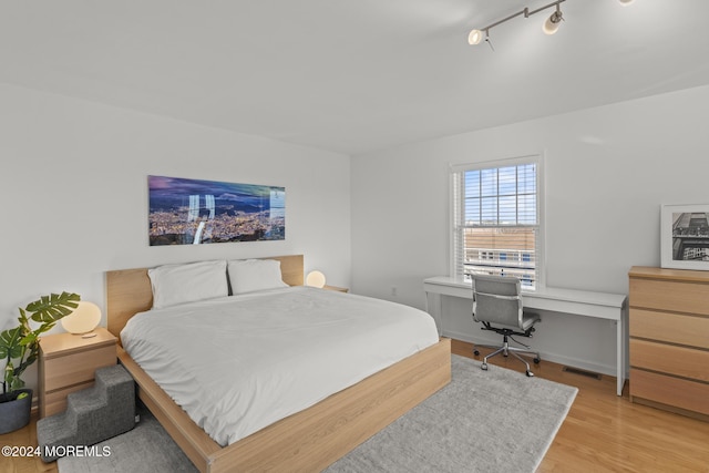 bedroom featuring light hardwood / wood-style floors and track lighting