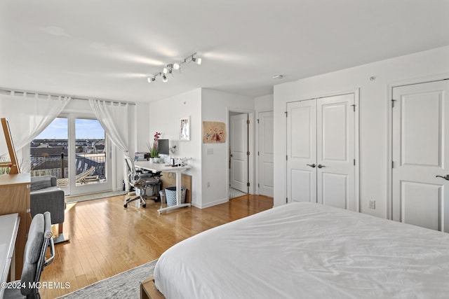 bedroom with access to exterior and wood finished floors