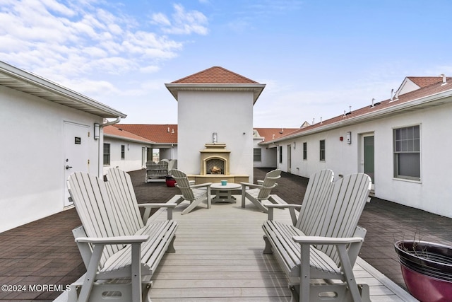 wooden terrace with a patio area and exterior fireplace