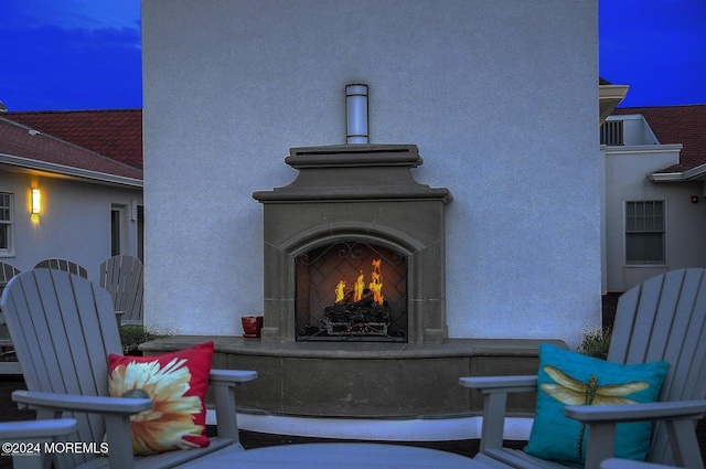 view of patio / terrace featuring a warm lit fireplace