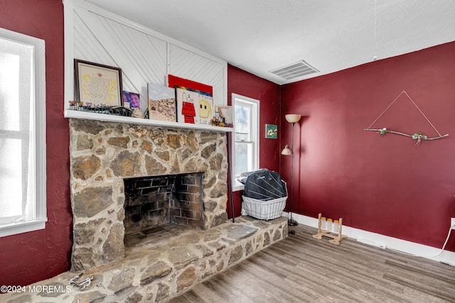 living room with a fireplace, plenty of natural light, and hardwood / wood-style flooring