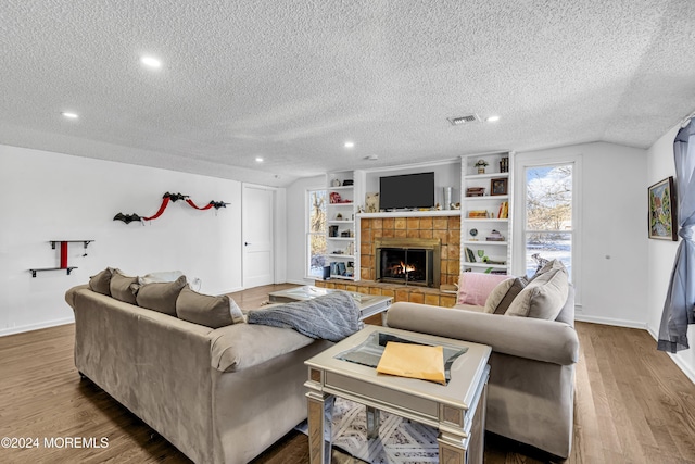 living room featuring a fireplace, a textured ceiling, and hardwood / wood-style flooring