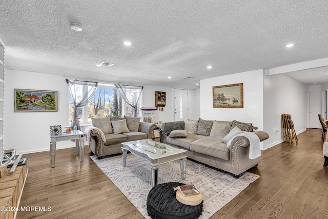 living room with light hardwood / wood-style floors and a textured ceiling