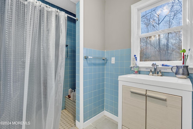 bathroom with a shower with shower curtain, vanity, tile walls, and tile patterned floors