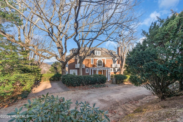 view of front of home with driveway and a chimney