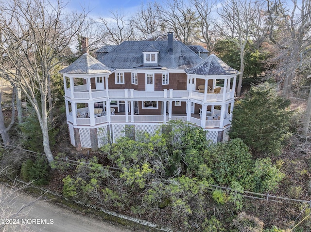 back of property featuring a gazebo, a balcony, and a chimney