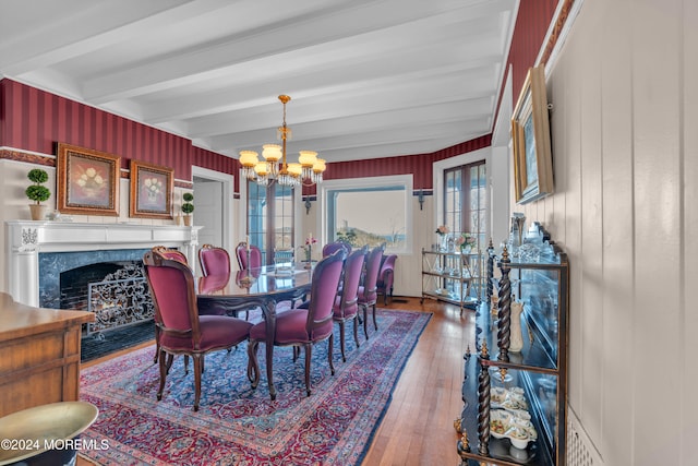 dining space featuring beamed ceiling, plenty of natural light, a chandelier, and hardwood / wood-style flooring