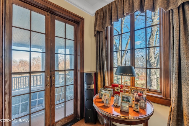 doorway to outside with crown molding and french doors