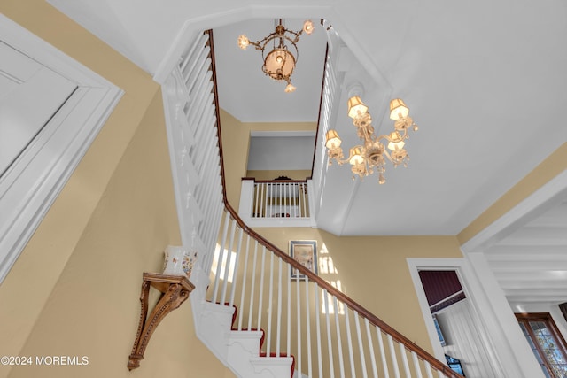 stairs featuring a chandelier and a towering ceiling