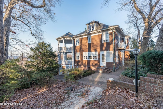 view of front of home with entry steps and a balcony