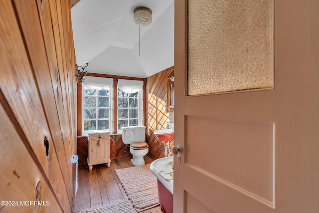 bathroom featuring toilet, hardwood / wood-style floors, and vaulted ceiling