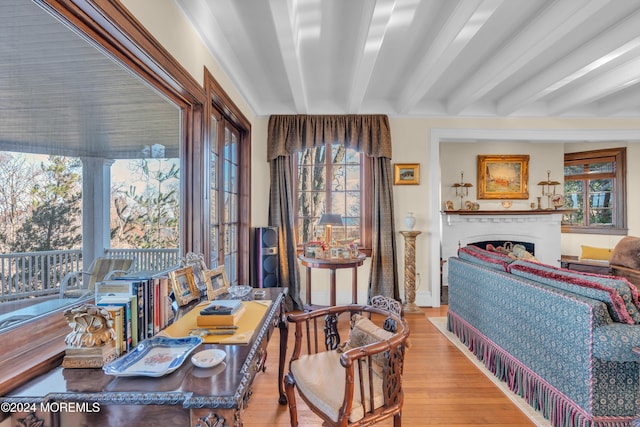 interior space featuring beamed ceiling, wood finished floors, and a fireplace