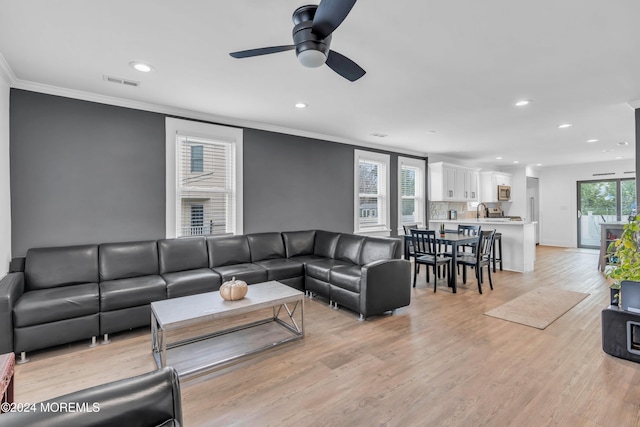 living room with crown molding, sink, ceiling fan, and light hardwood / wood-style floors