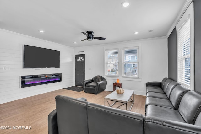 living room featuring wood-type flooring, ceiling fan, and ornamental molding