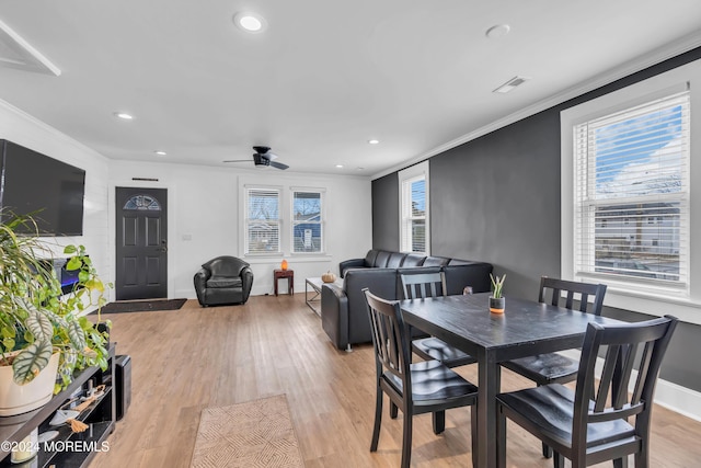 dining area featuring a healthy amount of sunlight, ceiling fan, crown molding, and light hardwood / wood-style floors